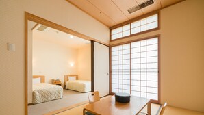 A traditional Japanese room with tatami flooring, a low wooden table, and a shoji screen door. - Gokurakuji Onsen Arcadia Village (Hatsukaichi)