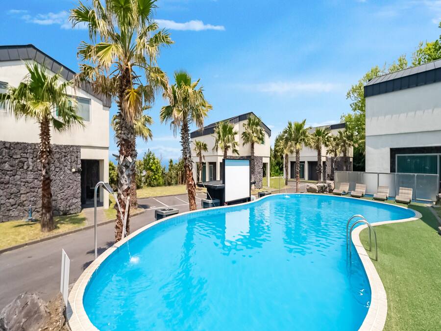 En säsongsöppen utomhuspool och solstolar