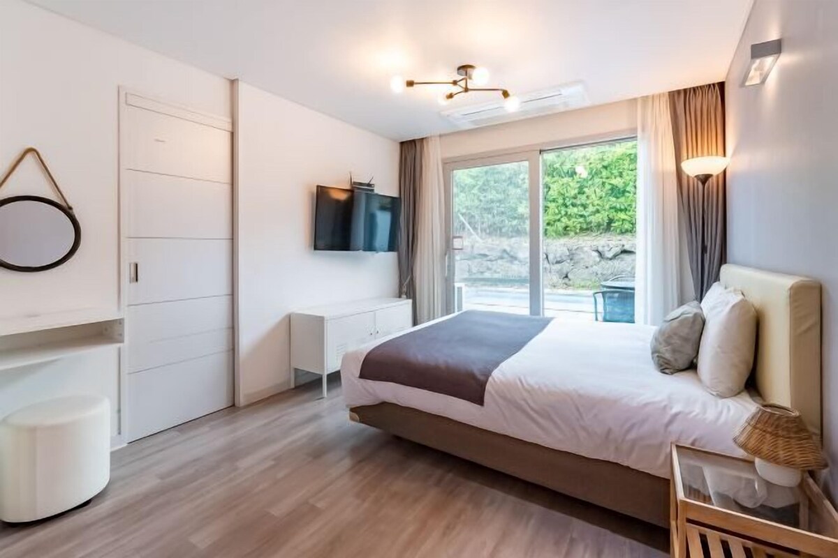 Un dormitorio moderno con una cama grande, un escritorio y un televisor.
