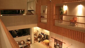 A multi-level interior with wooden paneling, a staircase, and a visible store on the lower level. - Breezbay Shuzenji Hotel (Izu)