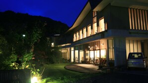 A modern two-story building with large windows and a covered outdoor seating area. - Breezbay Shuzenji Hotel (Izu)