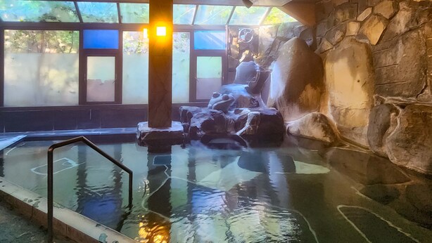 A hot spring area with stone walls and a glass barrier. - Breezbay Shuzenji Hotel (Izu)
