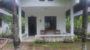 A covered porch with a stone floor, white columns, and a bench. - Privacy Resort Koh Chang (Ko Chang)