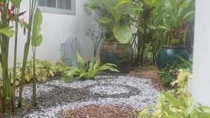 A garden with a gravel path, various plants, and a large decorative pot. - Privacy Resort Koh Chang (Ko Chang)