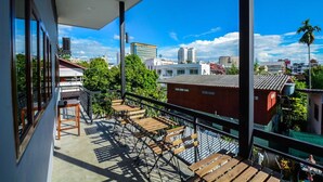 A balcony with wooden furniture and a city view. - The Ghee House (Chiang Mai)
