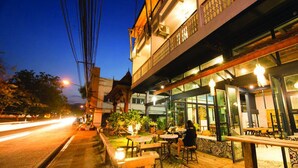 Un restaurante con terraza, balcón y vistas a la calle.