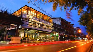Un edificio de varios pisos con restaurante en la planta baja y espacios residenciales o comerciales en los pisos superiores.