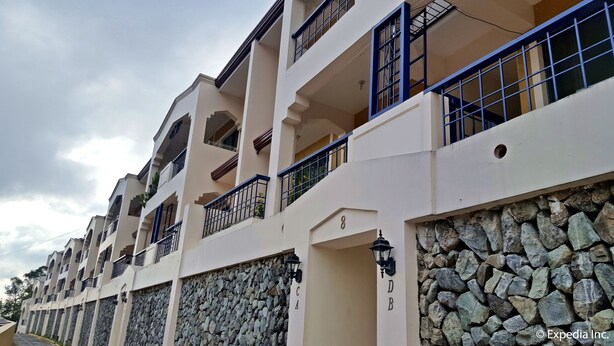 A multi-story residential building with balconies, stone walls, and a row of windows. - Baguio Vacation Apartments (Baguio)