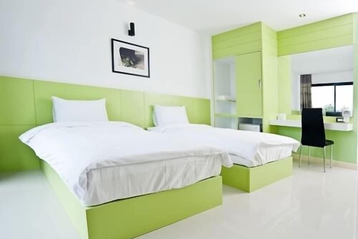 Un dormitorio moderno con dos camas, un escritorio y una silla.