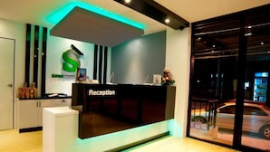 Un mostrador de recepción de diseño moderno, con un gran logo S y un cartel indicador.