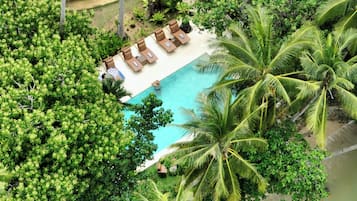 Alberca al aire libre, sombrillas en la alberca y camastros