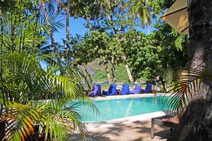 Una piscina al aire libre, sombrillas, tumbonas