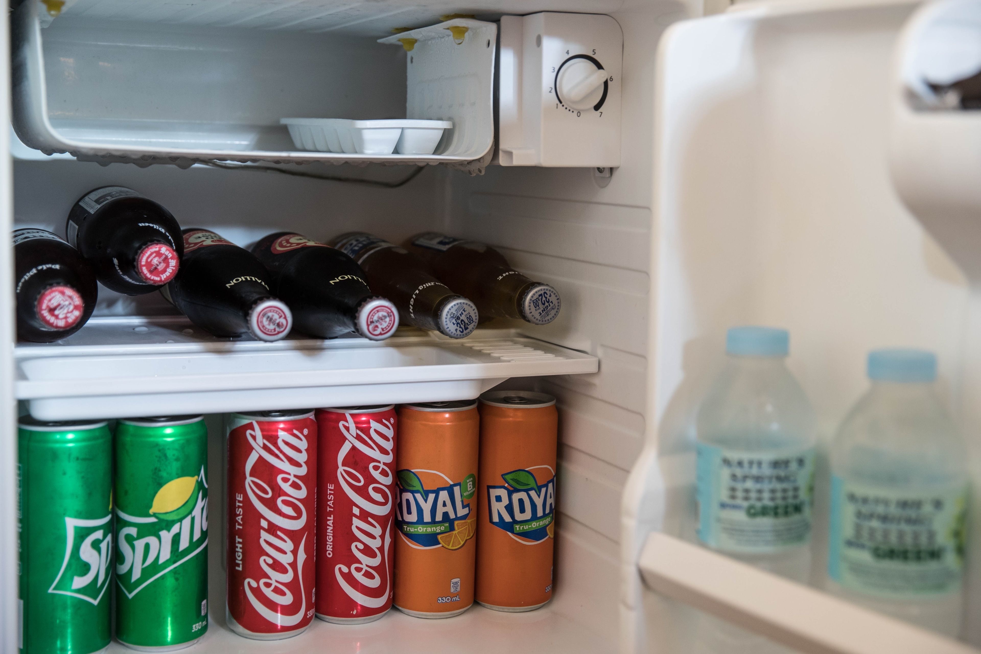 Geladeira com diversas bebidas, incluindo Sprite, Coca-Cola e Royal Truborange.