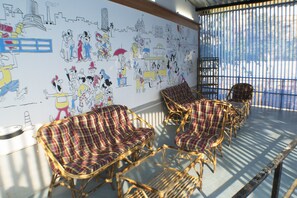 A room with wicker chairs and a mural on the wall. - Arma Hostel Mumbai (Mumbai)