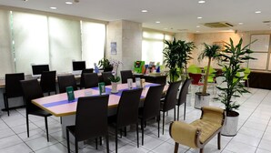 A conference room with a long table, black chairs, and potted plants. - Kyoto Plaza Hotel (Kyoto)