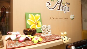 A wooden counter with a sign reading "Anju" and a decorative arrangement including flowers and figurines. - Kyoto Plaza Hotel (Kyoto)
