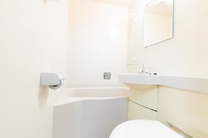 A modern bathroom with a white sink, mirror, and toilet. - Hotel Toka (Tokyo)