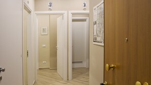 A hallway with wooden flooring, white walls, and doors leading to different rooms. - Marbia Guest House (Bologna)