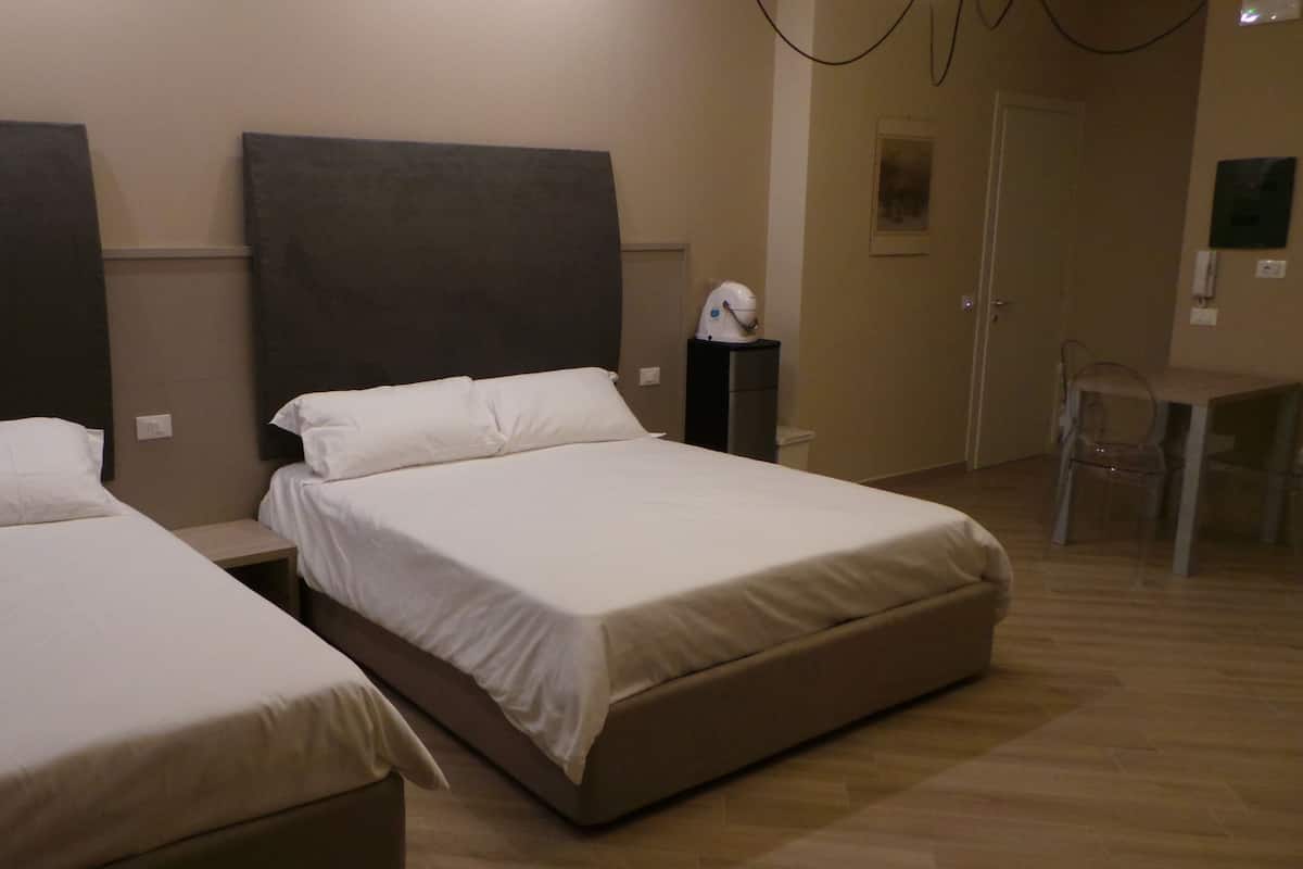 Una habitación de hotel con dos camas individuales, un escritorio pequeño y una silla.