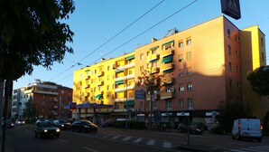 A multi-story building with a yellow facade, multiple balconies, and a pedestrian crossing. - Marbia Guest House (Bologna)