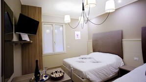 A hotel room with a bed, bedside table, and a TV mounted on the wall. - Marbia Guest House (Bologna)