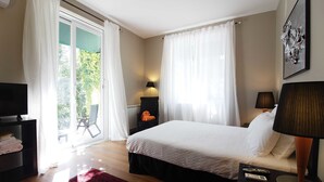 A bedroom with a bed, two bedside lamps, a TV, a red rug, and a view of the outdoors through a sliding door. - Halma - Nature & Sea (Palmela)