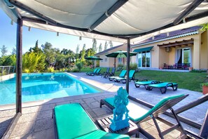 A poolside area with lounge chairs, umbrellas, and a statue. - Halma - Nature & Sea (Palmela)