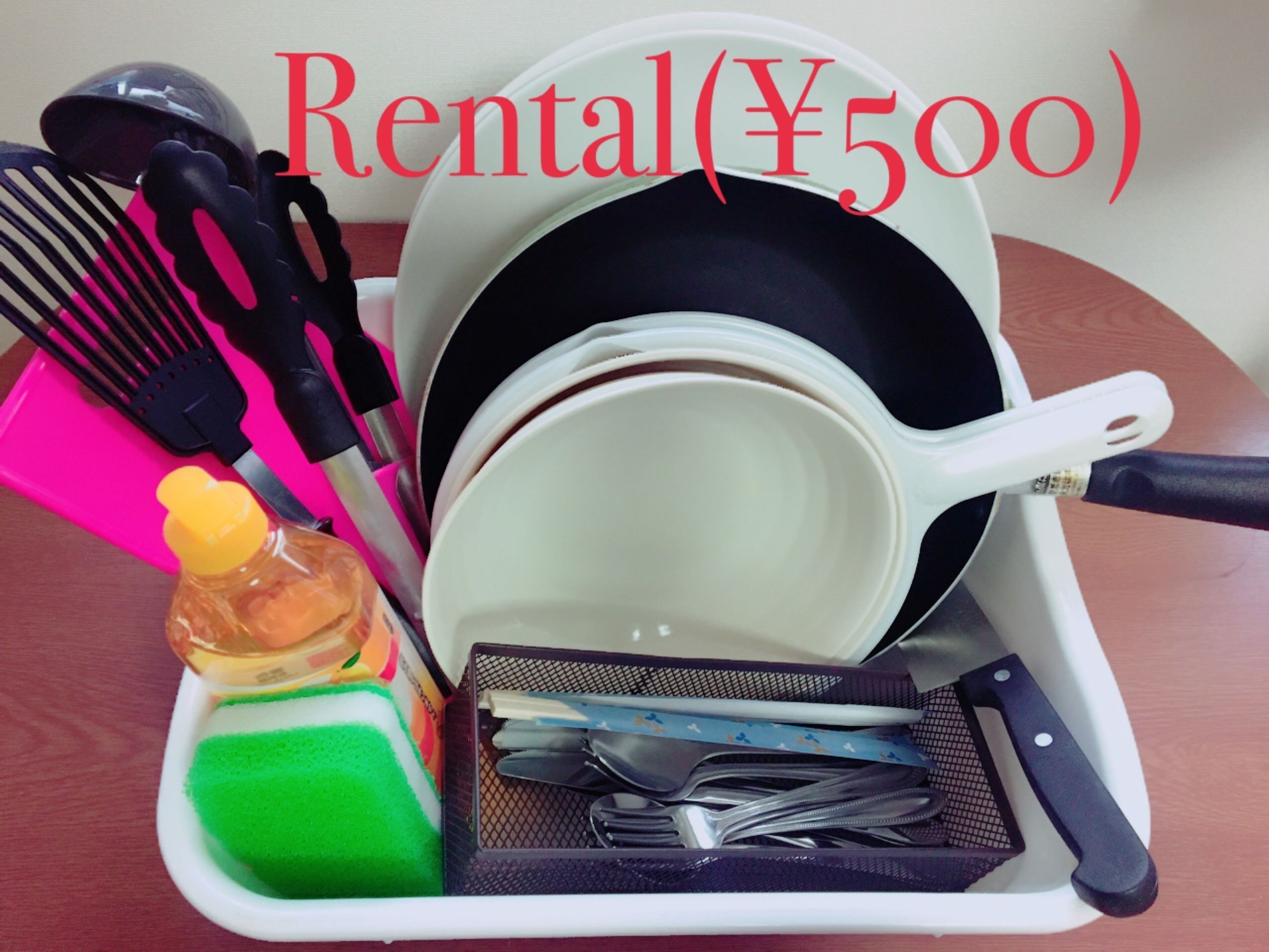 A kitchen setup with utensils, a frying pan, a pot, and a sponge.