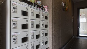 Eine Reihe von Metallschließfächern mit Gebrauchsanweisung, angebracht an einer strukturierten Wand in einem Flur.