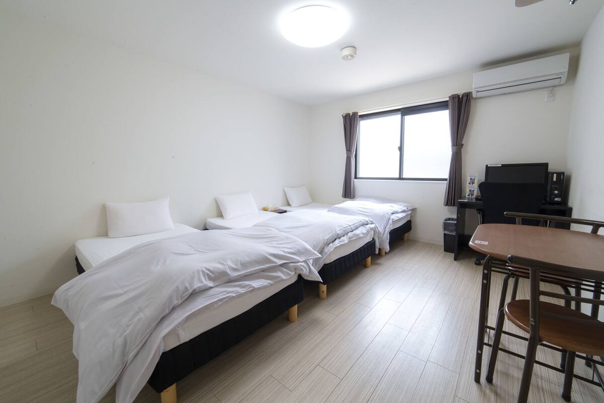 Een kamer met twee bedden, een bureau en een stoel.