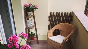 A small balcony with wicker furniture, a potted plant, and a ladder. - Domus Mea- Adults Only (Verona)