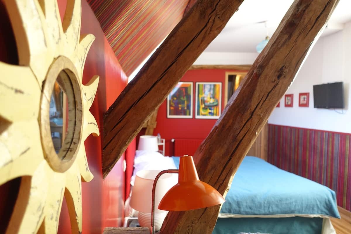 A room with a bed, a lamp, and a wooden structure.