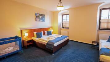 Habitación de hotel con una cama individual, una mesita de noche pequeña, un ventanal con persianas y un cuadro en la pared.