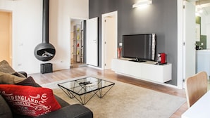 A modern living room with a fireplace, television, and a cozy seating area. - At Home Spanish Steps (Rome)