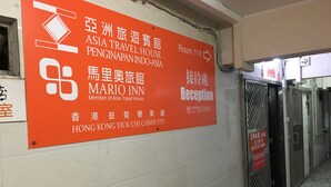 Un cartel de hotel con varios idiomas e indicaciones hacia la recepción.