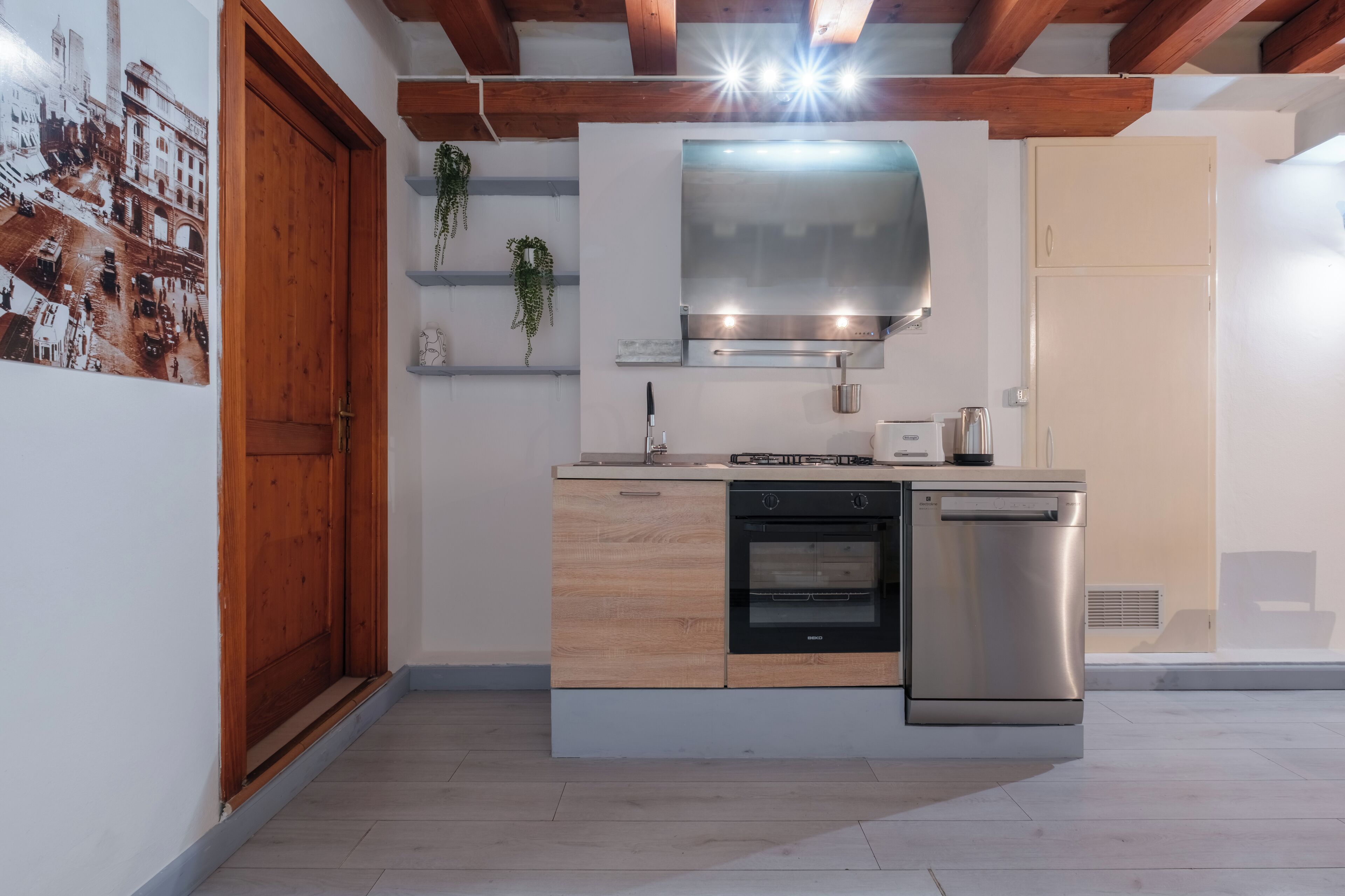 A modern kitchen with a built-in oven, a dishwasher, and a stainless steel range hood.