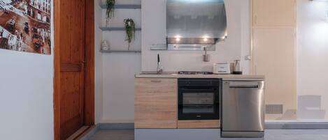 Een moderne keuken met een ingebouwde oven, een vaatwasser en een roestvrijstalen afzuigkap.