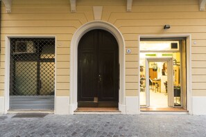 Un edificio con una puerta negra, un letrero con el número 8 y una entrada a una tienda.