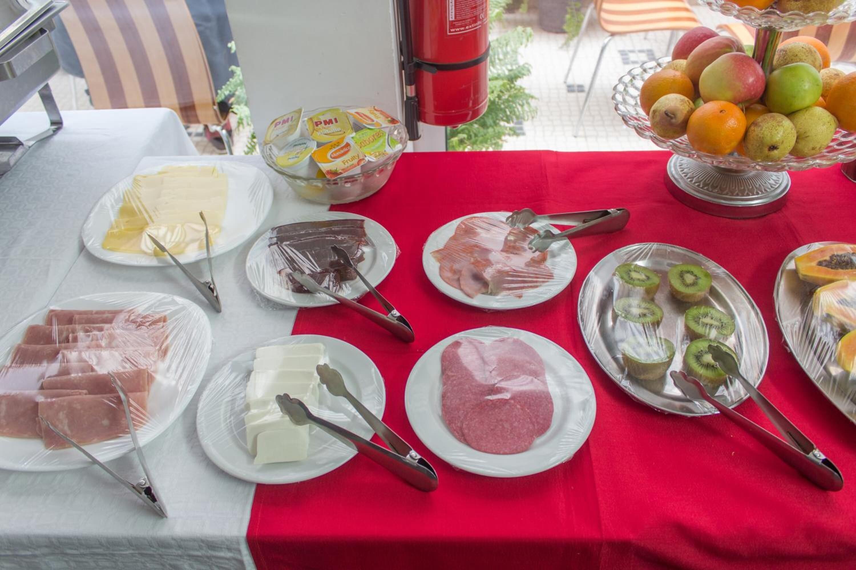 Ett buffébord med olika sorters mat, inklusive kött, ostar och frukt.