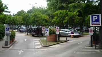 A parking area with multiple signs indicating parking rules and directions.