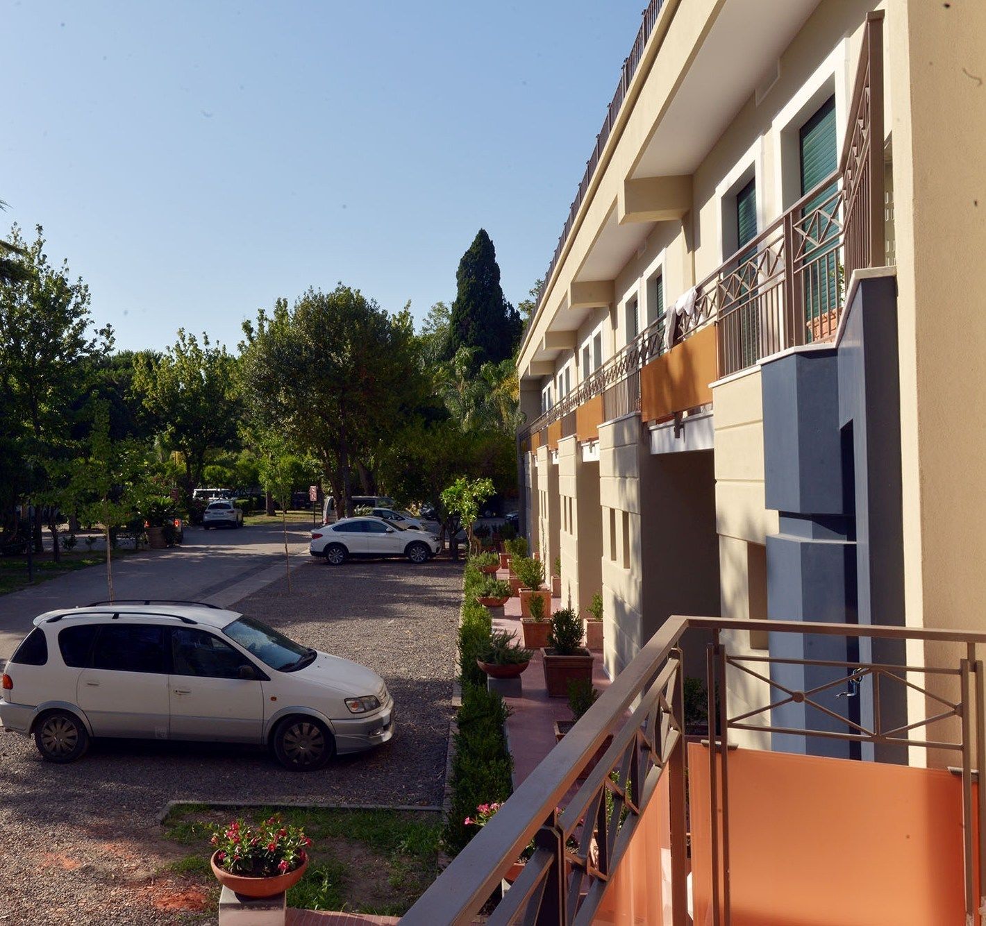 Un edificio de varios pisos con un área de estacionamiento al frente.