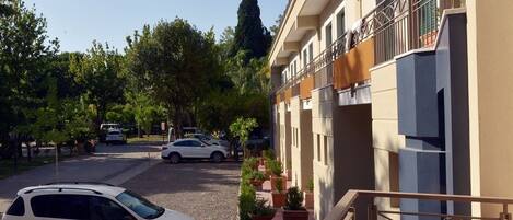 Un edificio de varios pisos con un área de estacionamiento al frente.