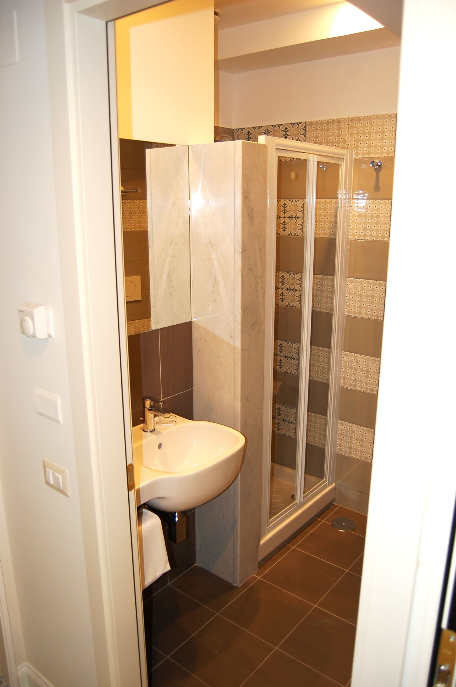 Un baño con lavamanos, espejo y cabina de ducha.