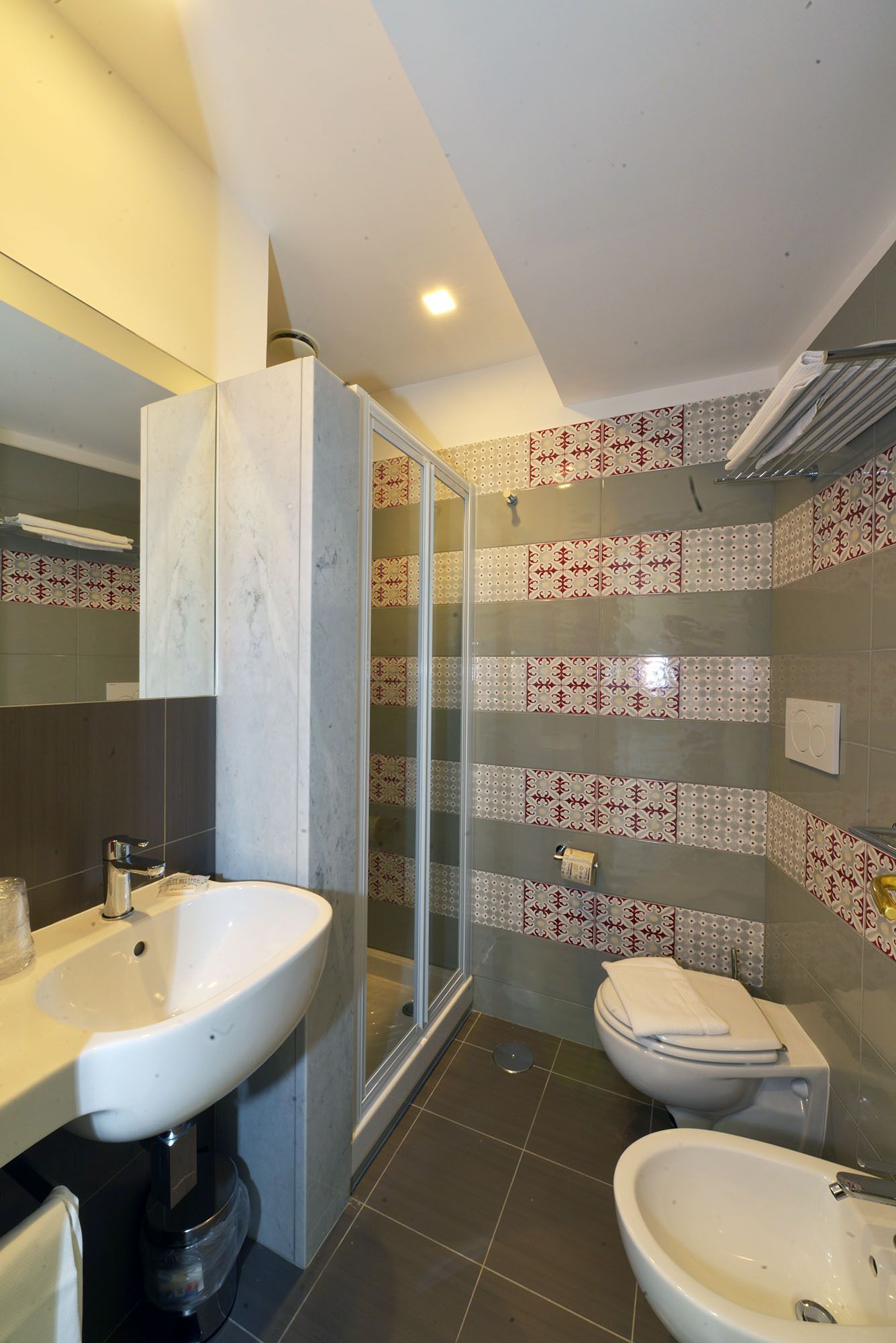 A bathroom with two sinks, a toilet, and a glass-enclosed shower.