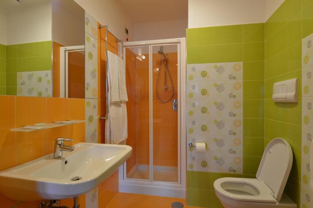 Ein Badezimmer mit Dusche, Waschbecken und Toilette.
