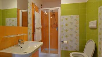 Une salle de bain avec une douche, un lavabo et des toilettes.