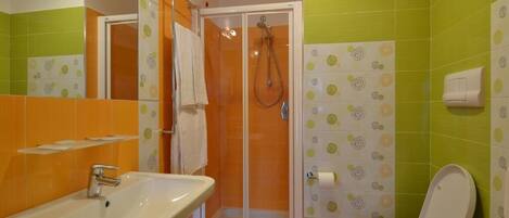 A bathroom with a shower, sink, and toilet.