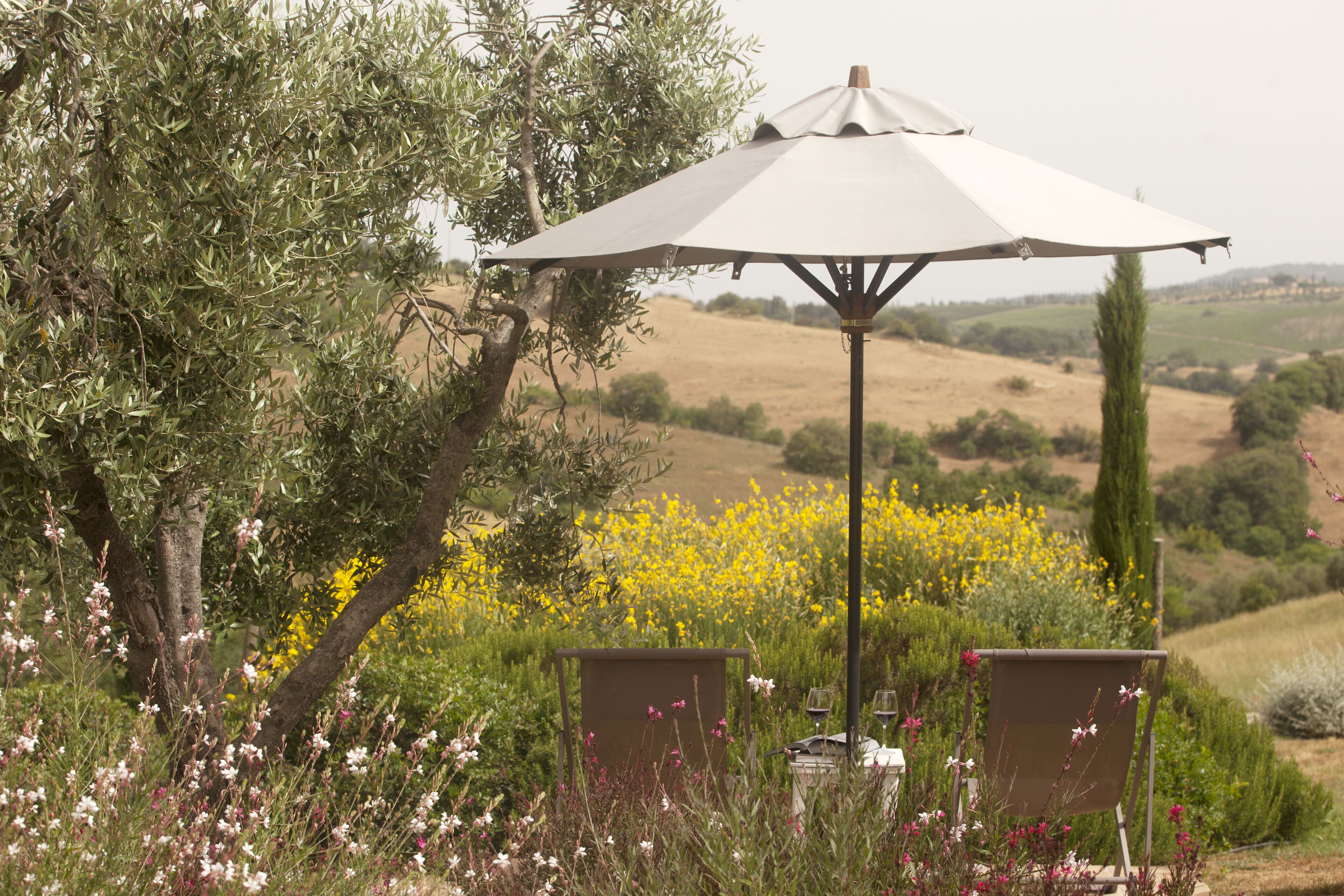 Un espace extérieur aménagé avec une table, des chaises et un parasol.