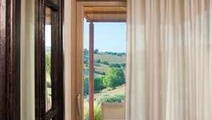 A room with a sliding glass door leading to an outdoor patio. - Casale Sterpeti (Magliano in Toscana)