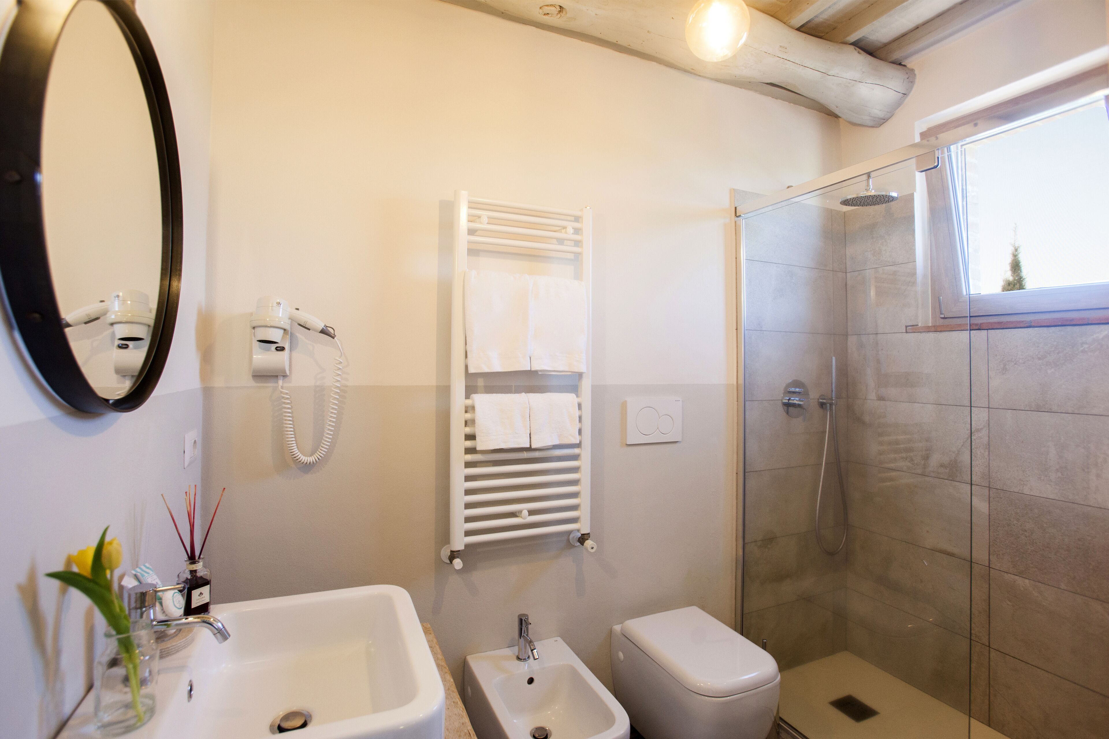 Bagno con lavandino, bidet, WC e cabina doccia in vetro.